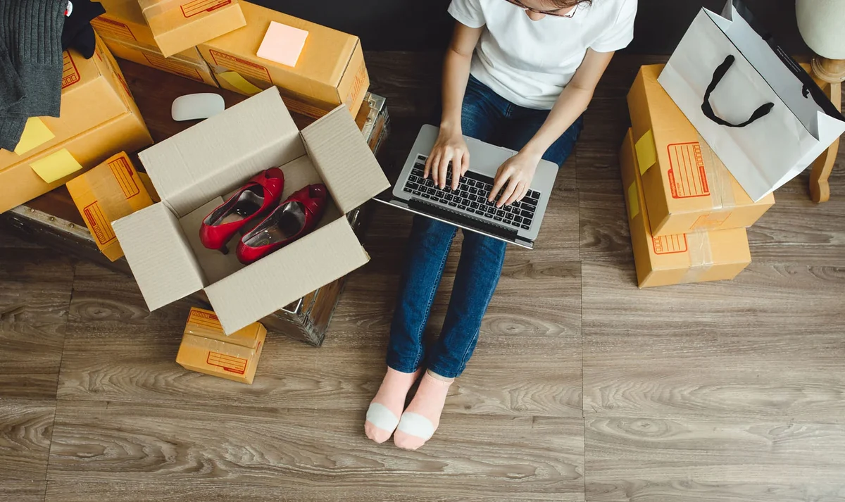 Image depicting a woman using a laptop while sat on the floor